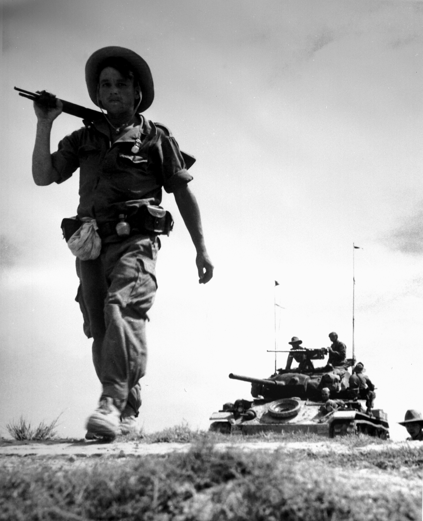 French Foreign Legionnaire in Indochina with a U.S.-gifted M24 Chaffee visible in the background, circa 1954. Red River Delta between Haiphong and Hanoi. image is Shows service context but the tank is background and partly obscured. URL/.