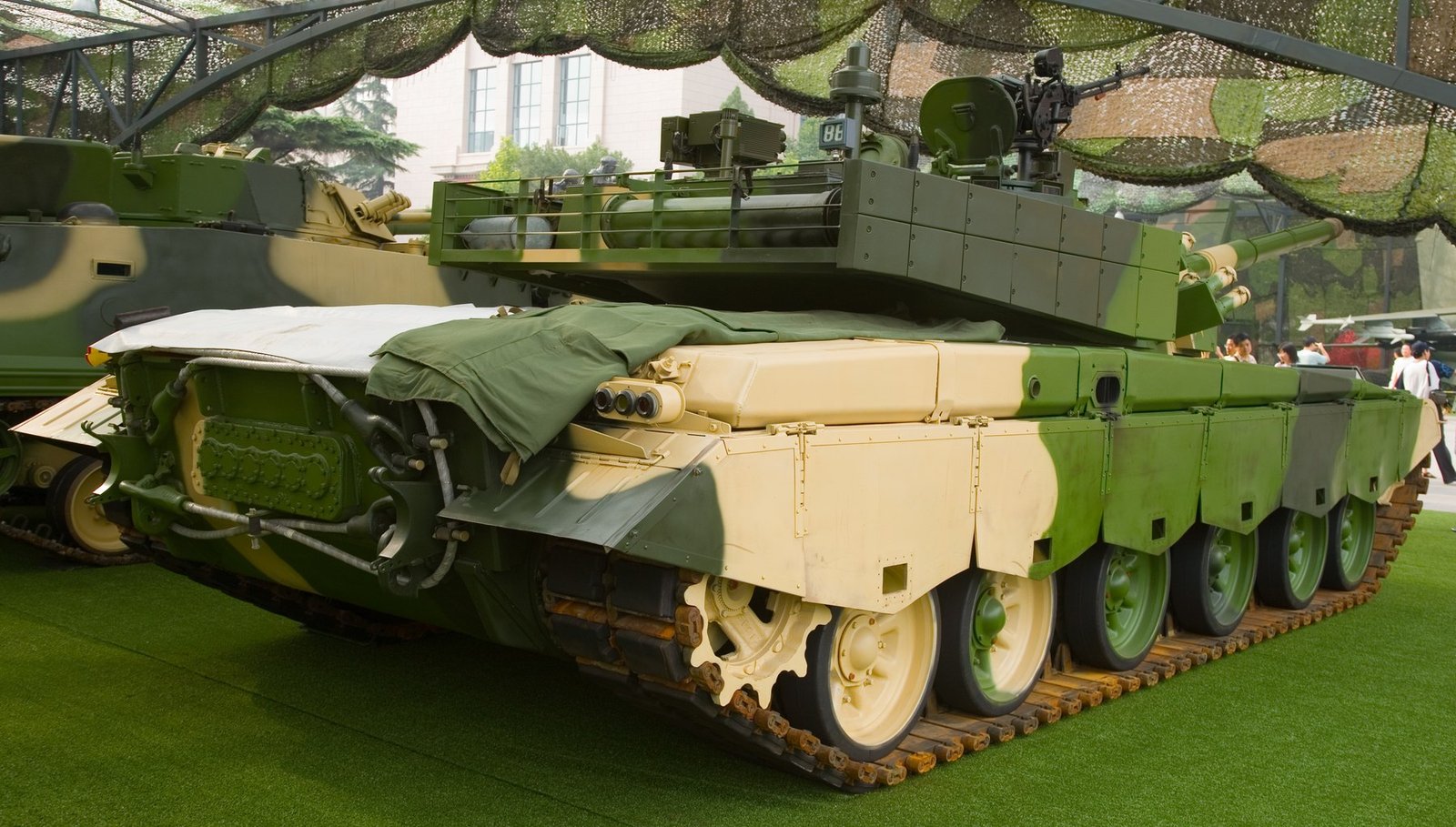 Type 99 MBT rear/side view at the Beijing Military Museum, “Our troops towards the sky” exhibition, August 2007. Shows rear hull, external fuel drum/stowage area, and side-skirt layout; museum display context.