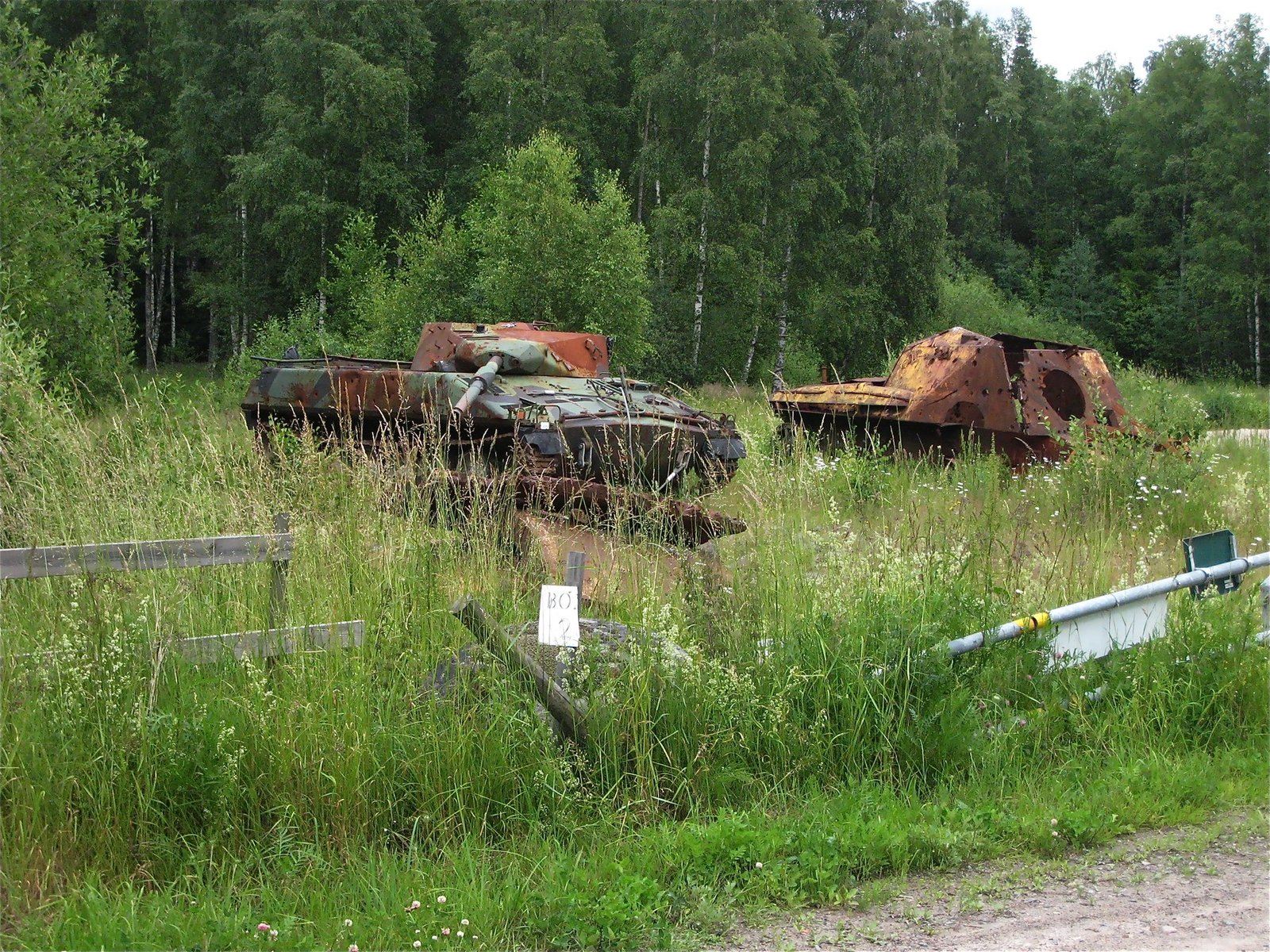 Utö Skjutfält scene with Commons annotation identifying an Infanterikanonvagn 91. 5 July 2009. Utö firing range / Utö Skjutfält context. broader range/survivor context; not a service-action photograph.