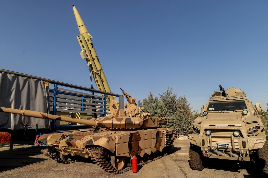 Karrar at Iranian Ministry of Defense achievements exhibition, 2022. Karrar main battle tank displayed at an Iranian Ministry of Defense achievements exhibition. 27 August 2022. Iran; precise exhibition venue not stated in the Commons metadata. static display, not an operational image; Shows uncloaked exterior comparison. Source.
