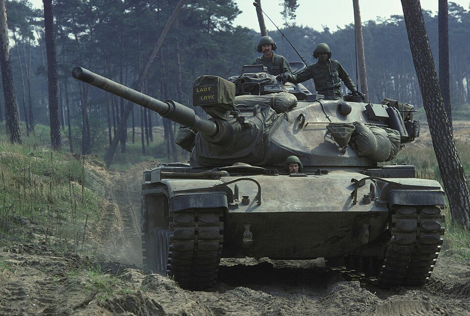 U.S. Army soldiers operate an M60A1 main battle tank during a field training exercise, 1 May 1975. The photo shows the M60A1 turret form and Cold War field-service context. Credit: U.S. National Archives record 6399291 via Wikimedia Commons; photographer unknown.