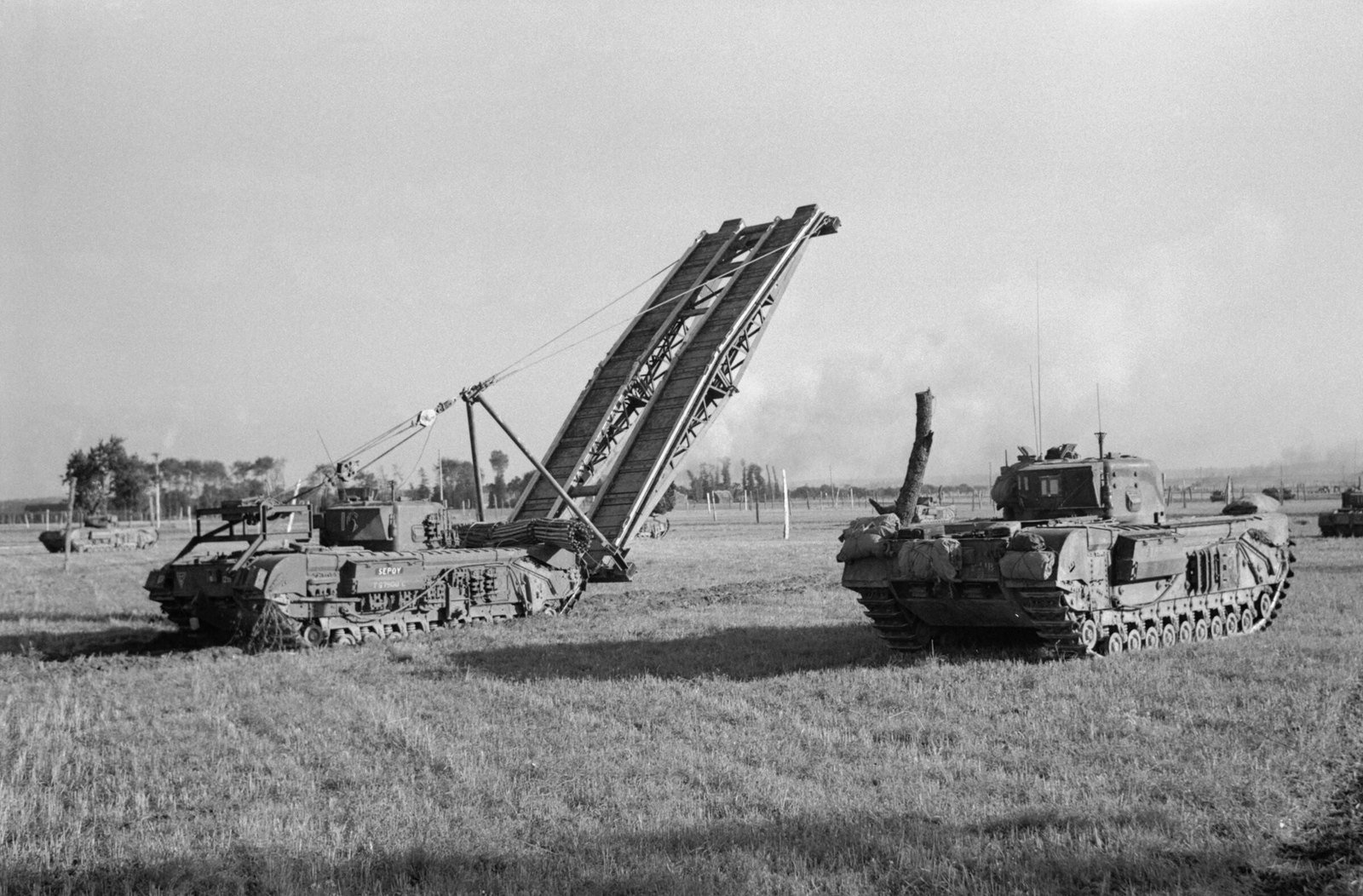 Churchill tanks and a bridgelayer of 34th Tank Brigade during the assault on Le Havre, 13 September 1944. Le Havre area, France. illustrates the specialist engineer branch of the family.
