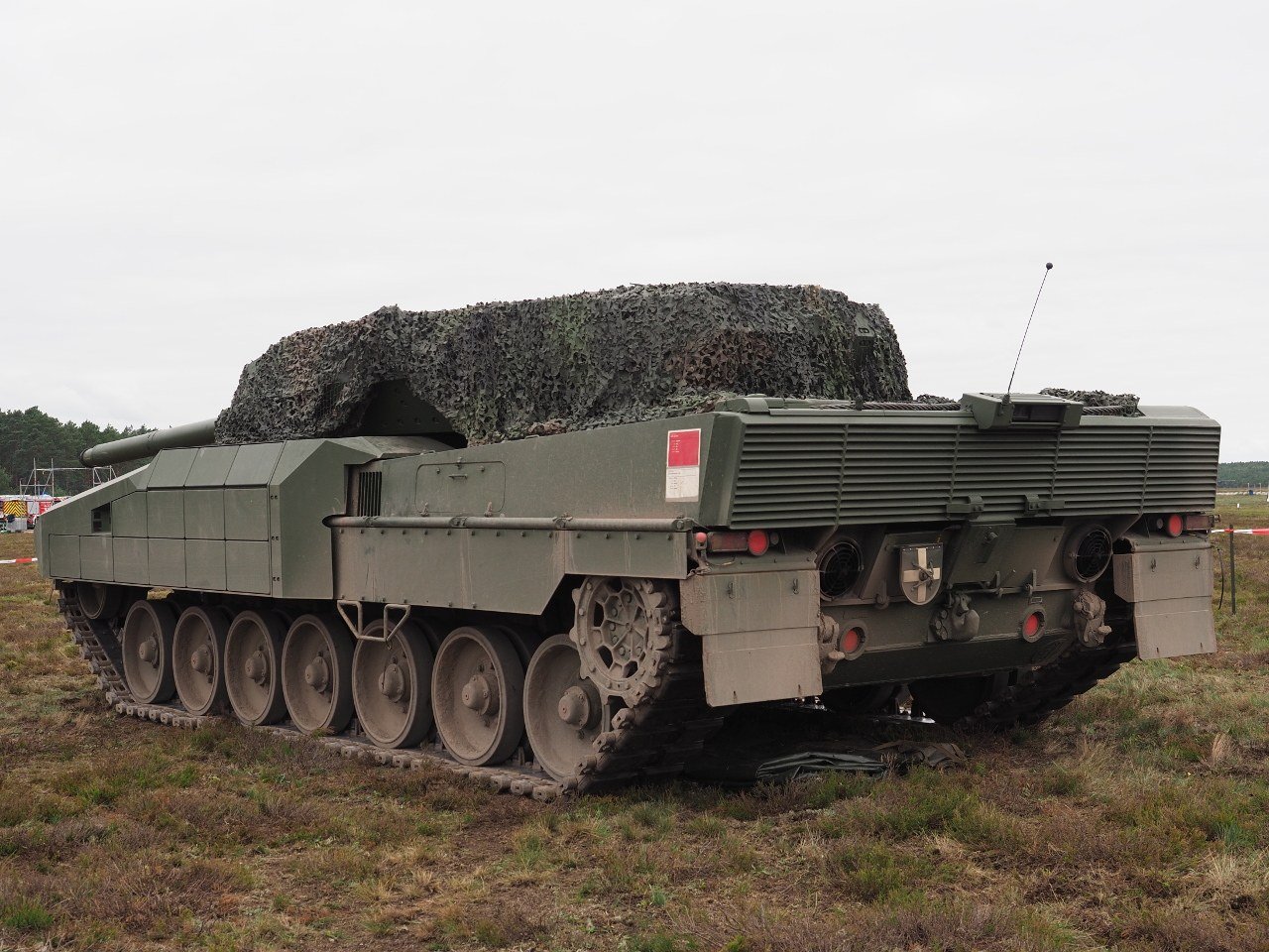 KNDS Leopard 2 A-RC3.0 test vehicle PT02, rear-quarter view, on static display during Open Day at Klietz training area 2025. 26 July 2025. Klietz / Schonhauserdamm auxiliary airfield, Brandenburg, Germany. rear view helps show retained Leopard 2-like automotive layout and demonstrator hull form. [Commons Back 2025].